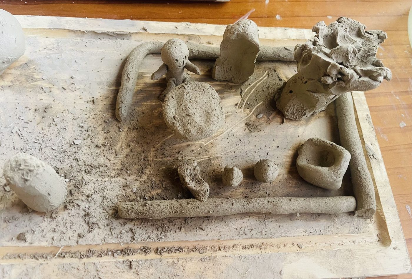Formas modeladas em argila sobre uma placa de madeira